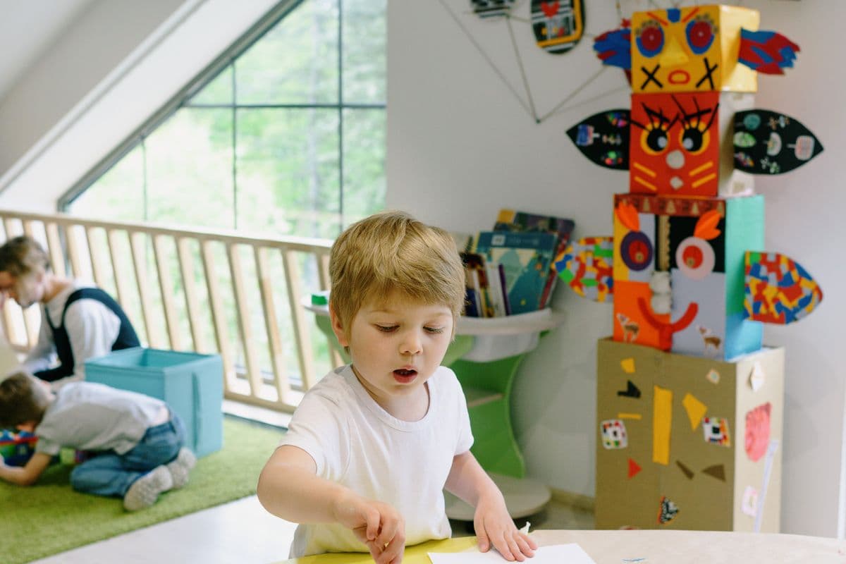 A three-year-old painting at a small table