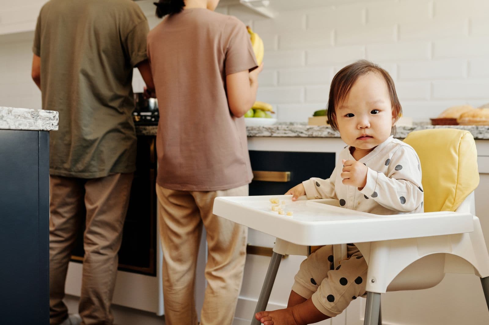 A baby eating finger foods in a high chair