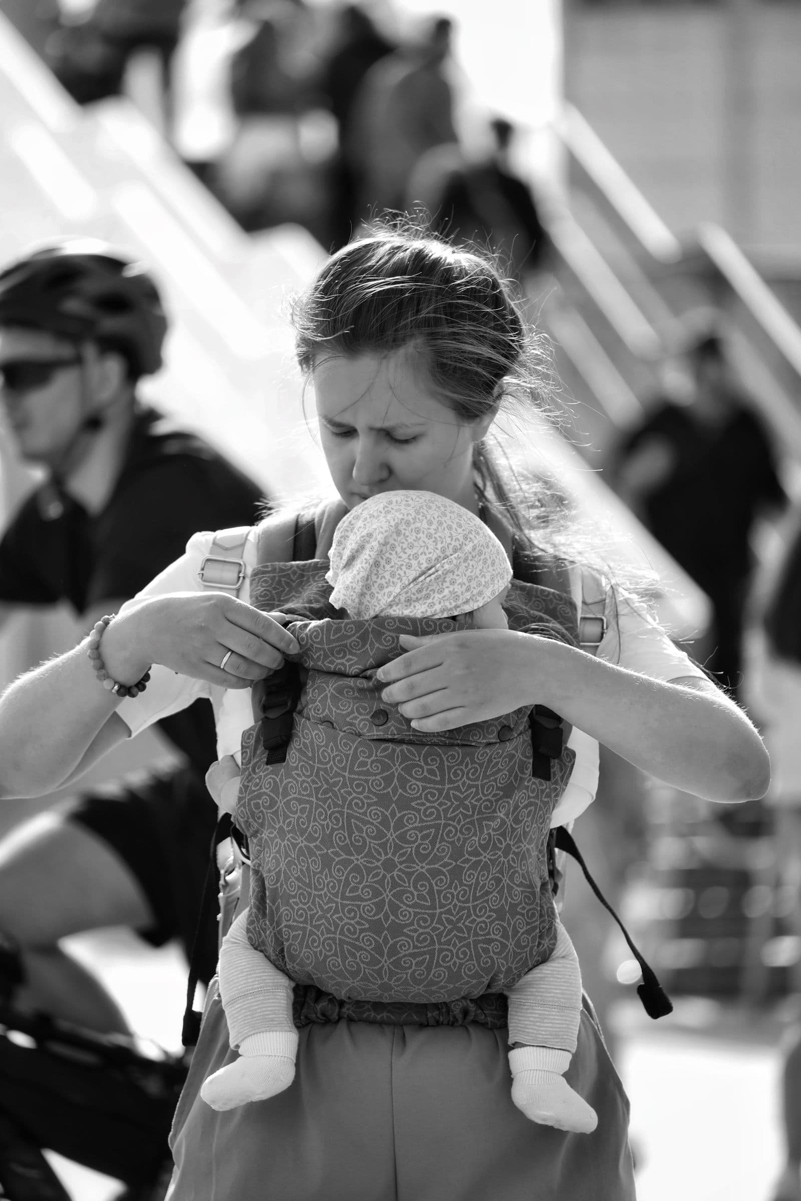 A parent carrying a baby in a structured front carrier while out walking