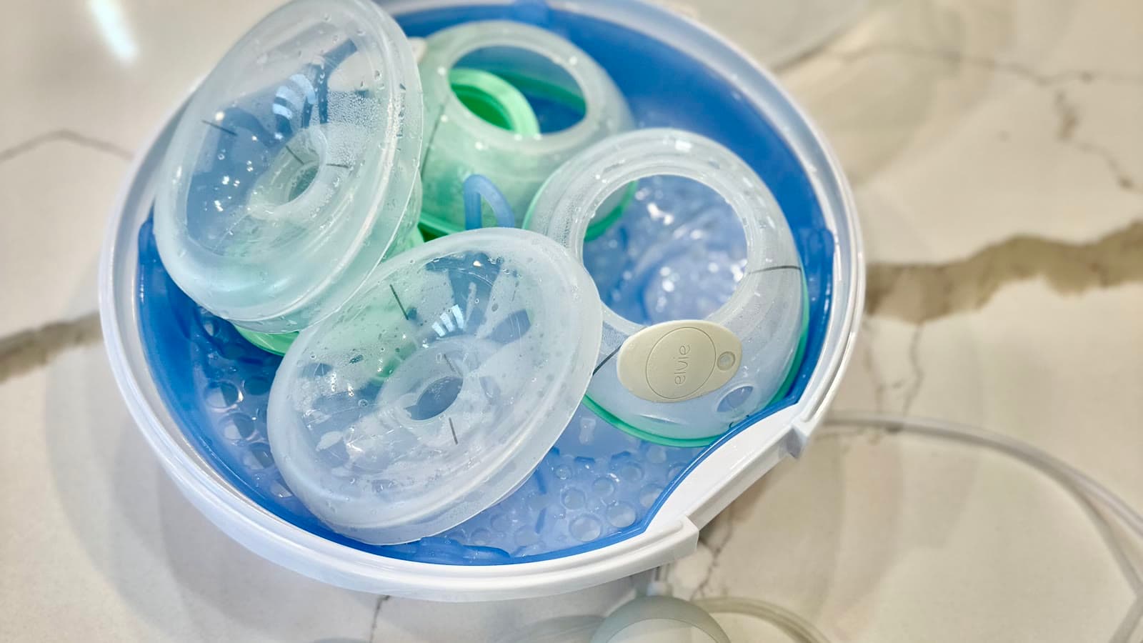 A wearable hands-free breast pump and collection cup on a white background