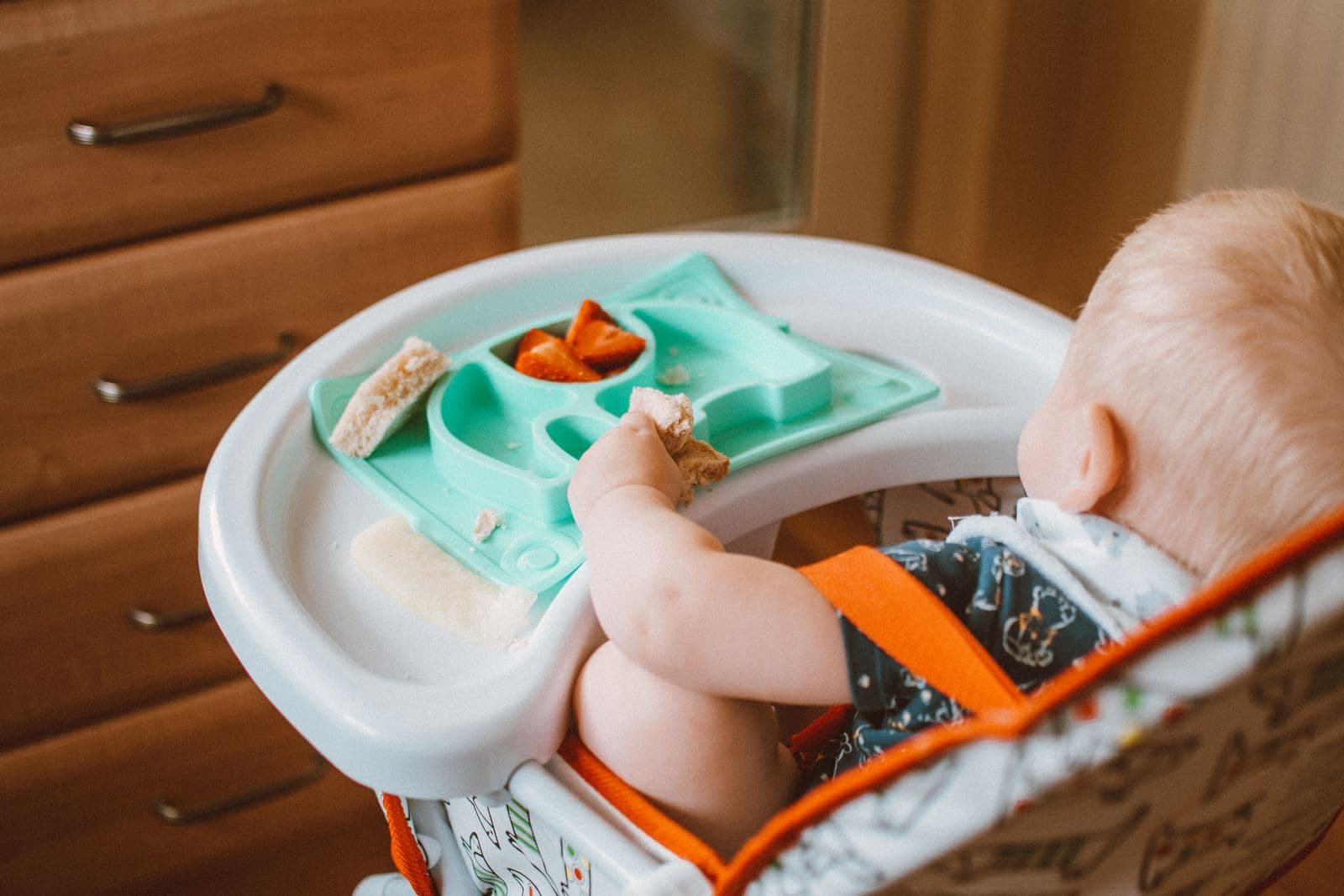 A young child eating in a high chair