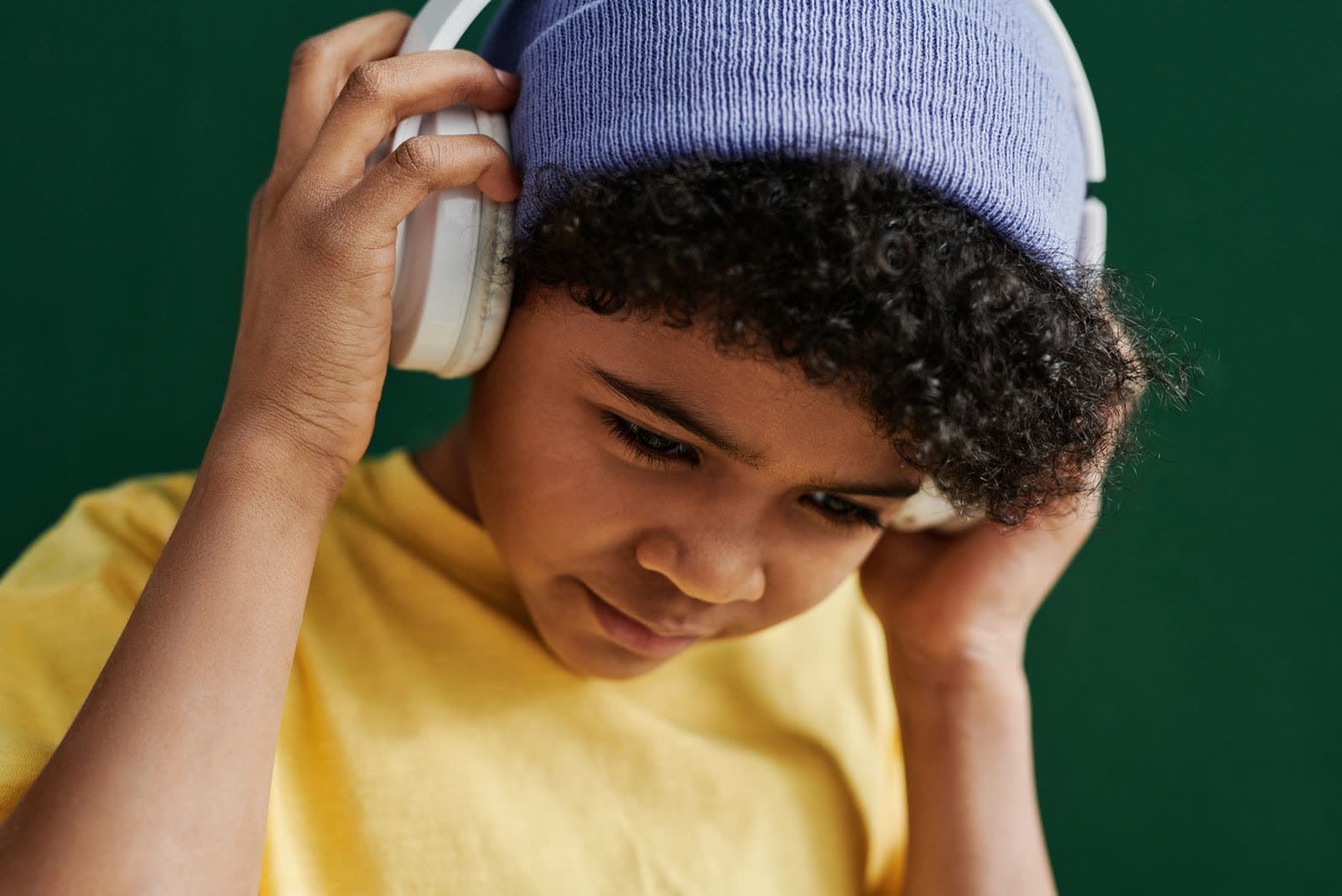 A young boy wearing white over-ear headphones