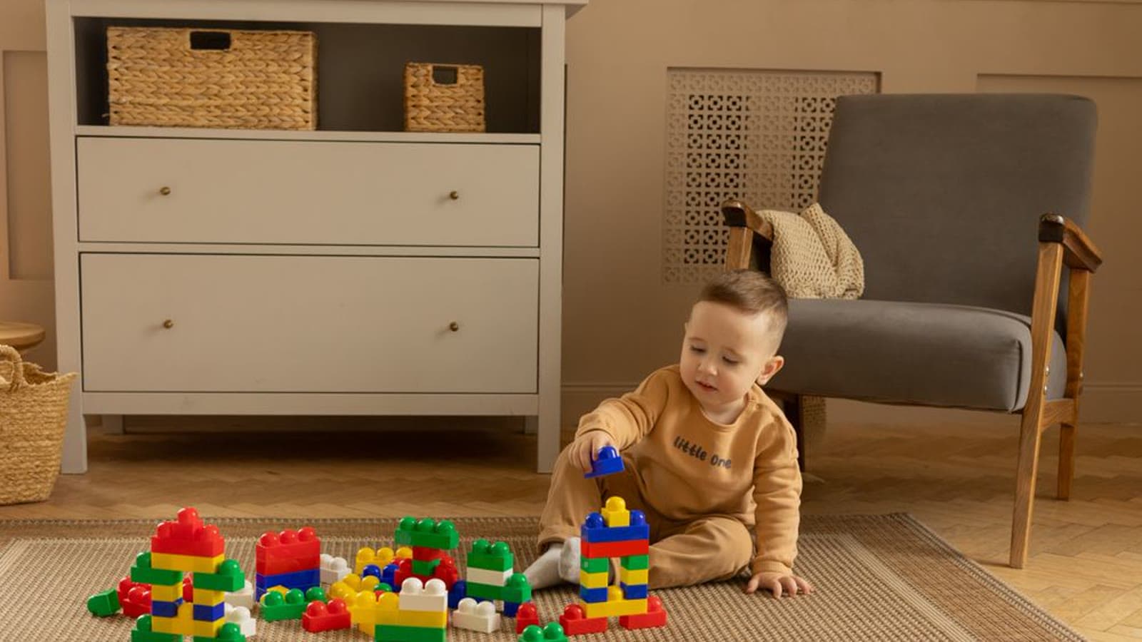 A toddler playing with colorful building blocks on a rug