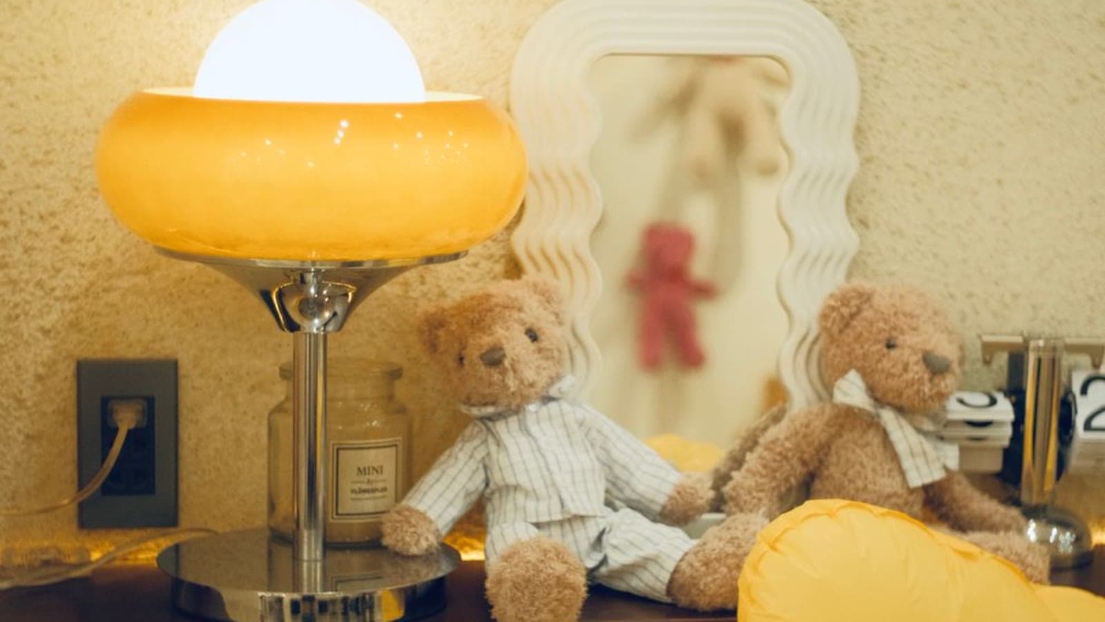 A nursery shelf with teddy bears and a small glowing lamp