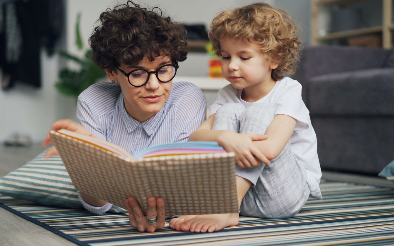 A parent and child reading a picture book together