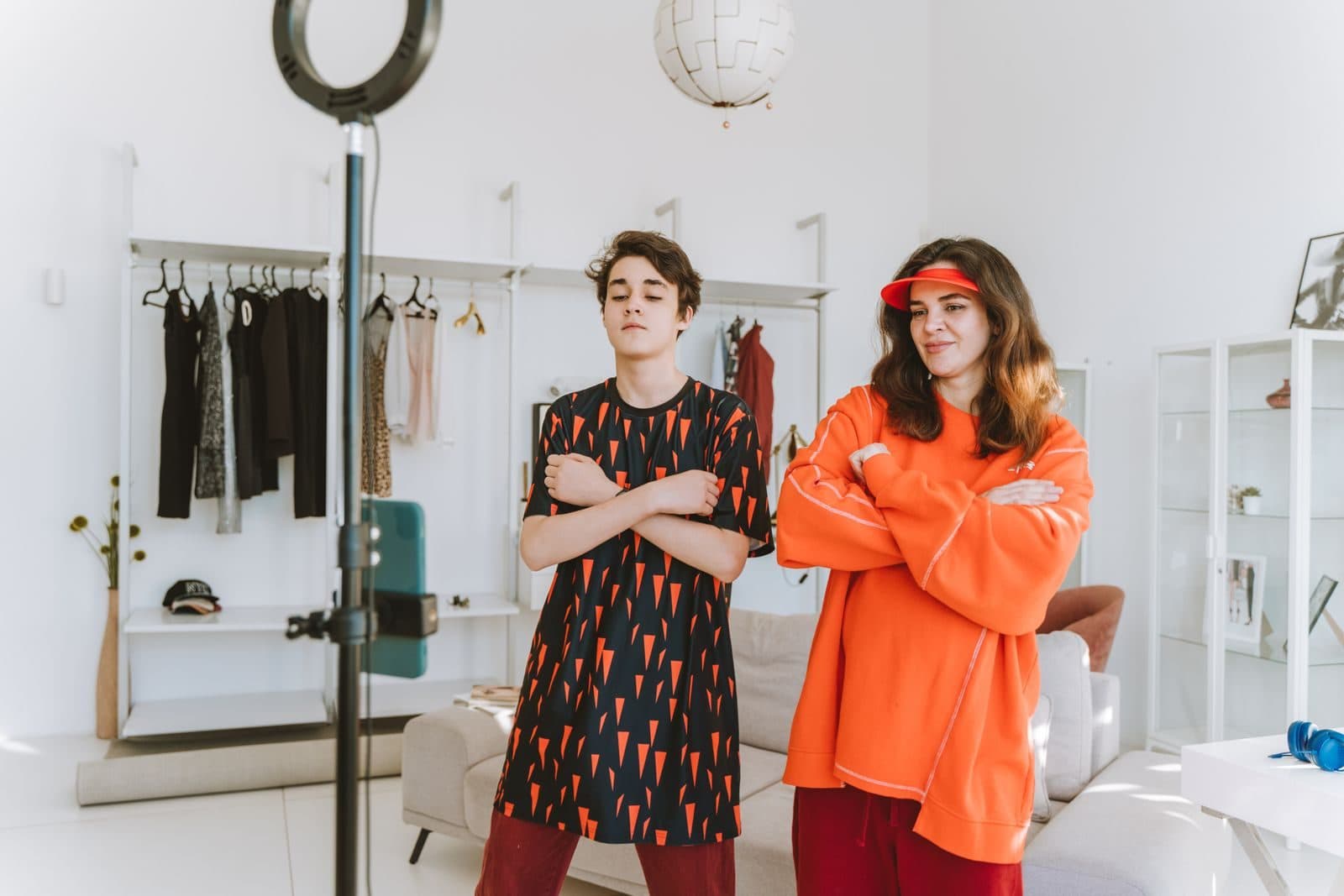 A mom and her son filming a video at home in front of a smartphone on a ring light stand