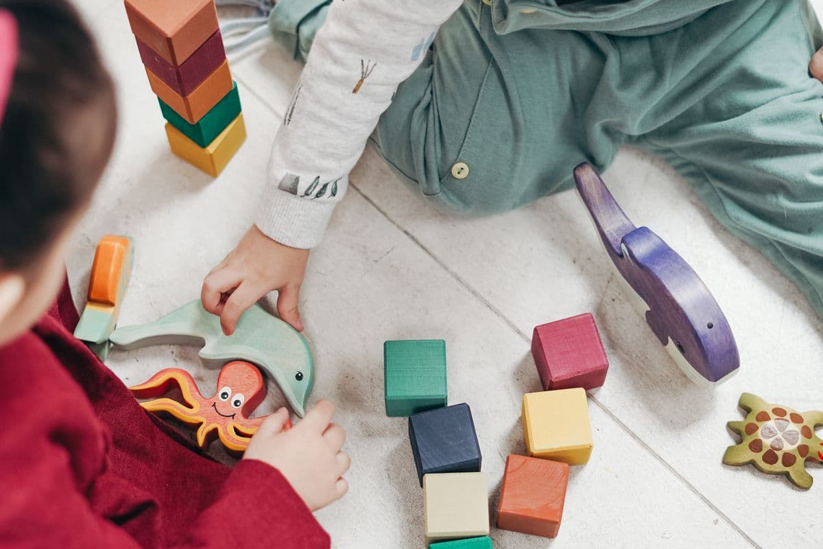 A toddler playing with simple household objects on a living-room floor