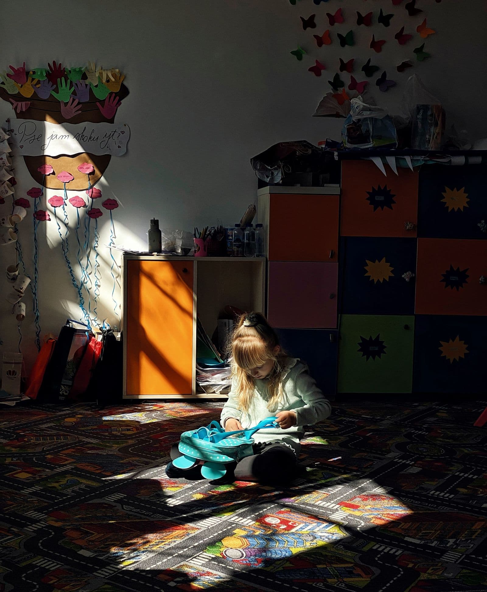 A young child with a backpack ready for kindergarten