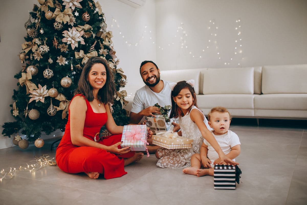 A family exchanging gifts together by the Christmas tree