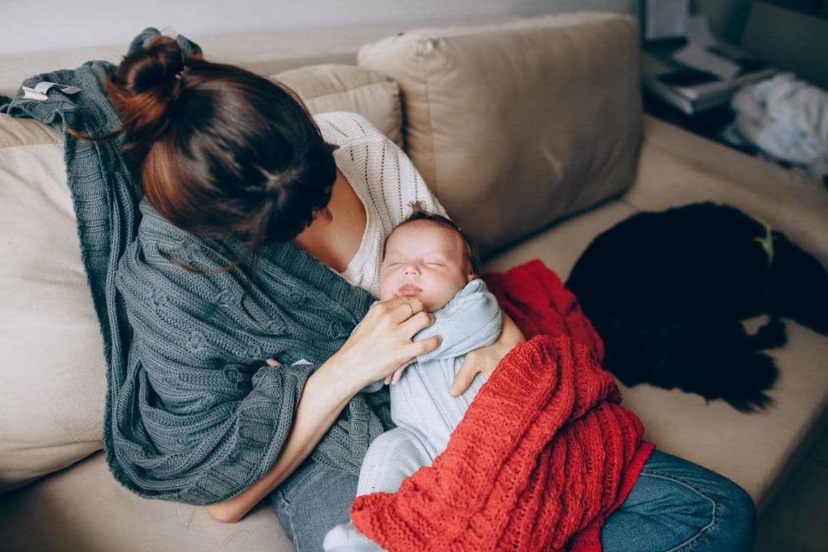 A mother resting at home with her newborn