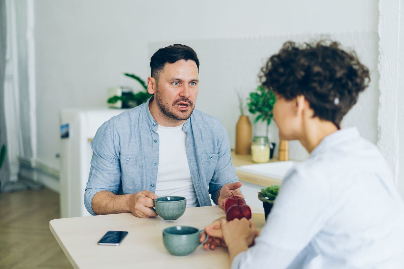 Two parents having a conversation at the kitchen table