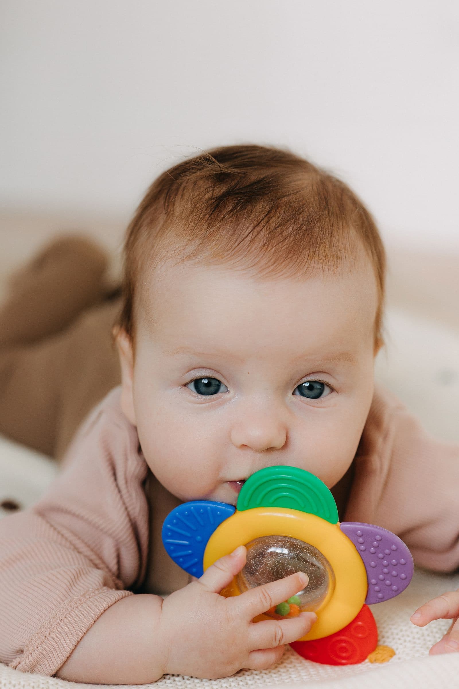 A baby chewing on a teething toy