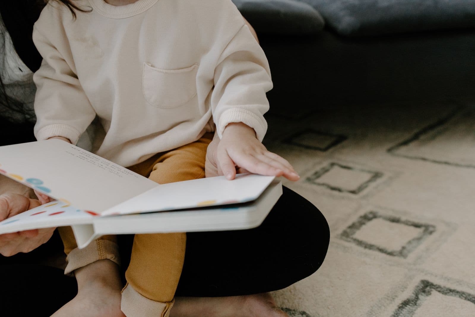 A parent talking and reading with a toddler face to face
