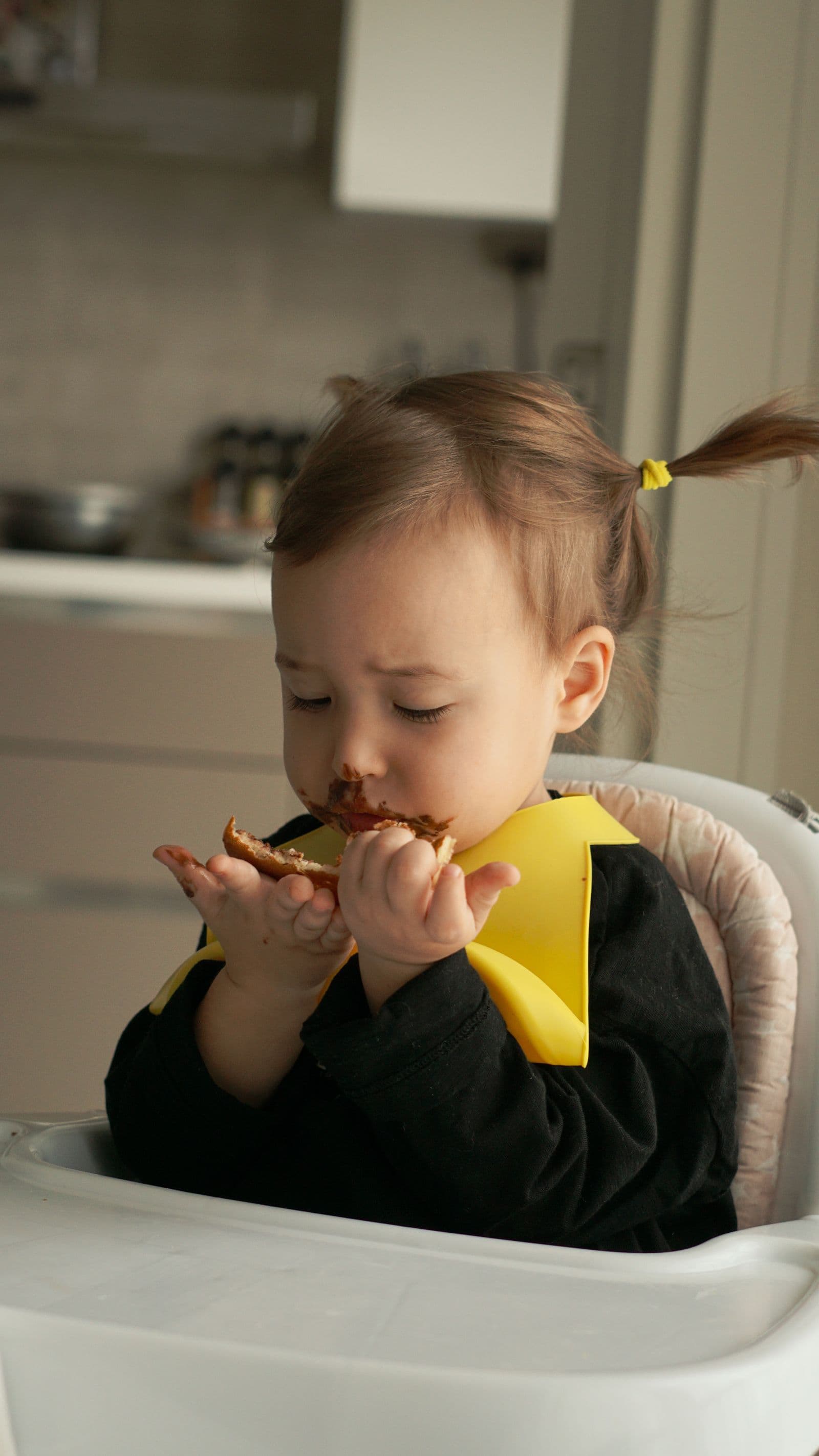 A toddler exploring food in a high chair